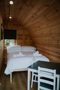 a bedroom with a bed and a table and chairs at Ash WINTER RETREAT- Hot tub & Log Bruner in Barmouth