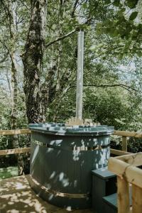 a water fountain sitting next to a wooden bench at Ash WINTER RETREAT- Hot tub & Log Bruner in Barmouth