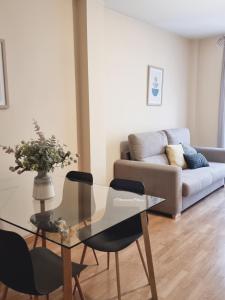 Apartamentos Salvia 4 في مدريد: غرفة معيشة مع طاولة وكراسي زجاجية