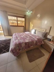 a bedroom with a large bed and a window at Résidence Hadja 01 in Dakar