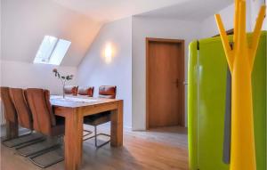 a dining room with a table and a green refrigerator at Pension Kuestenbrise in Elmenhorst