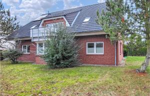 a red brick house with a balcony on top of it at Pension Kuestenbrise in Elmenhorst