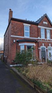 a red brick house with windows on a street at STAY - at Southport Holiday Home - sleeps 6 in Southport