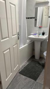 a bathroom with a sink and a toilet and a door at Huntingdon walk to town centre, cosy, Free parking in Huntingdon