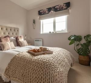 a bedroom with a bed with a tray of bread on it at The Wharf - Luxury Apartment in Warwick sleeps 4 with Free Parking - close to Canal-Side & pub - perfect for friends & family breaks, the races or work stays in Warwick