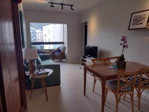 a living room with a table and chairs and a couch at Edifício Monte Carmel in Guarujá