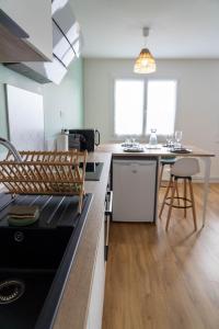 a kitchen with a black counter top and a table at Casa Ragazzi - Refait à neuf - Calme - Parking in Lempdes