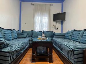 - un salon avec deux canapés et une télévision dans l'établissement La Perla Azul, à Chefchaouen
