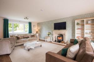 uma sala de estar com sofás e uma lareira em Luxurious & Modern Large 5 Bed House, HotTub, Views! em Maidstone