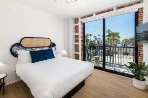 a bedroom with a large bed and a balcony at The Brick Boutique Hotel in Oceanside