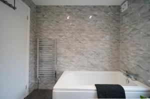 bagno con vasca bianca e parete in pietra di Perfectly located 4 bed town house in central Wetherby sleeps 8 a Wetherby Altre 11 foto