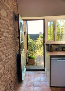 a kitchen with an open door to a patio at Pump Cottage - Cosy Herefordshire Cottage in Hereford