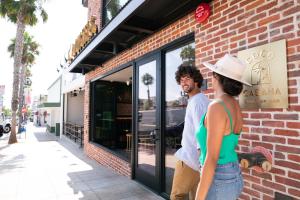 a man and a woman standing outside of a store at The Brick Boutique Hotel in Oceanside