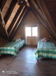 a attic room with two beds and a window at Casa En Punta Ballena Zona Chihuahua Mínimo tres noches in Punta del Este