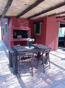 una mesa de madera con un jarrón de flores en el patio en Casa En Punta Ballena Zona Chihuahua Mínimo tres noches, en Punta del Este