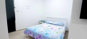 Dormitorio pequeño con cama con sábanas azules y moradas en 16 דירה מול הים ובריכה, en Bat Yam