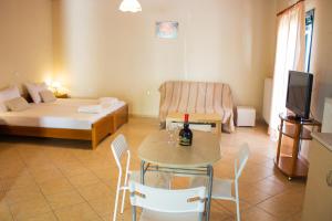 ein Wohnzimmer mit einem Bett und einem Tisch und Stühlen in der Unterkunft Nanos Studios in Parga