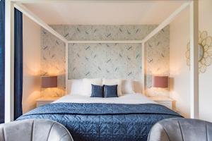 - une chambre avec un lit doté d'une couette bleue et de 2 chaises dans l'établissement Luxurious & Modern Large 5 Bed House, HotTub, Views!, à Maidstone
