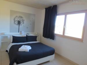 ein Schlafzimmer mit einem blauen Bett und einem Fenster in der Unterkunft Agriturismo Terra Del Vento in Genazzano