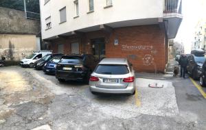 a parking lot with cars parked in front of a building at Apt by Trieste University in Trieste