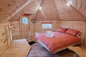 a bedroom with a bed in a wooden cabin at Woodland Cabin with Hot tub & log burner in Barmouth