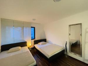 Cette chambre comprend 2 lits et un miroir. dans l'établissement Music Residence, à Sarrebruck