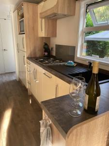 a kitchen with a bottle of wine and two glasses at Chalet Toetje op de Veluwe in Hoenderloo