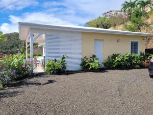 a house with a gravel driveway in front of it at VILLA INDEPENDANTE MAGNIFIQUE VUE MER DES CARAIBES in Le Marin