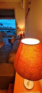 a living room with a couch and a lamp on a table at CANNES Front de Mer - Appartement 3 STAR in Cannes