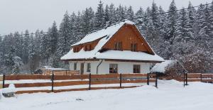 une maison avec un toit recouvert de neige dans l'établissement Chalupa U Juráša, à Horní Bečva
