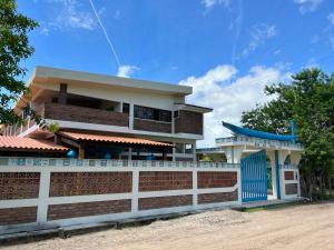 una casa con una valla delante de ella en Canoa Azul en Garapuá