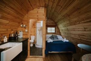 a bathroom with a bed in a wooden cabin at Snowdonia Mawddach Cabin + hot tub in Barmouth