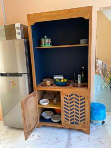 a kitchen with a shelf next to a refrigerator at Chez Ti Casa in Mahébourg