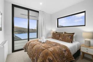 um quarto com uma cama e uma grande janela em Queenstown Terrace em Queenstown