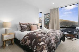 um quarto com uma cama, uma secretária e uma janela em Queenstown Terrace em Queenstown
