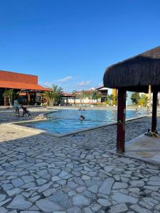uma piscina num resort com pessoas na água em Casa no Condomínio Village Praia dos Carneiros III em Praia dos Carneiros