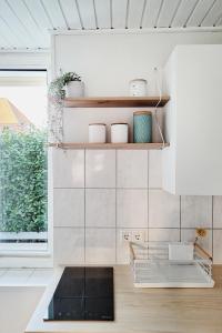 a kitchen with white walls and wooden shelves at Ferienhus #1 Nordfriesland in Mildstedt