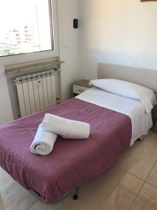 un letto con due asciugamani sopra di Attico Tacito a Ventimiglia