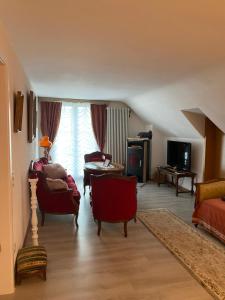 een woonkamer met stoelen en een bank en een tv bij Dream apartment in nice villa near forest in Brügg