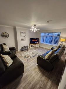 uma sala de estar com dois sofás e uma televisão em House on the Furrows em Luton