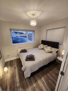 a bedroom with a bed with towels on it at House on the Furrows in Luton