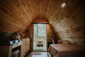 eine Hütte mit einer Küche mit einem Bett und einem Fenster in der Unterkunft Willow SPECIAL WINTER OFFER - Hot tub & Log burner in Barmouth