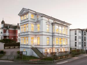 a white building with yellow lights on it at OSTKÜSTE - Villa Groth Design Apartments in Heringsdorf