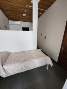 1 dormitorio con 1 cama en una habitación blanca en Departamento ubicadisimo calle chile con estacionamiento incluido capital Mendoza 6 en Mendoza