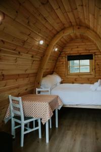Zimmer mit 2 Betten und einem Tisch in einer Hütte in der Unterkunft Oak SPECIAL WINTER OFFERS - Hot tub & Log burner in Barmouth