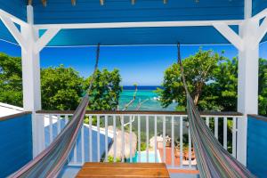 a porch with hammocks and a view of the ocean at Casa de Suenos Home in Sandy Bay