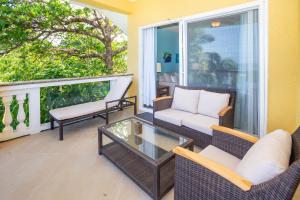 a balcony with wicker chairs and a glass table at Del Playa #4 Condo in West End