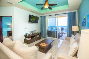 a living room with a couch and a ceiling fan at Del Playa #4 Condo in West End