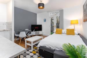 a bedroom with a bed and a desk and a kitchen at FLATZY - Stylish Abode on Doorstep of Sefton Park *10 minutes to Centre* in Liverpool