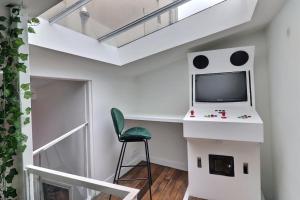 Habitación pequeña con escritorio y TV en la pared. en Unique loft apartment Located 15 minutes from the Champs Élysées, en Saint-Ouen 12 fotos más